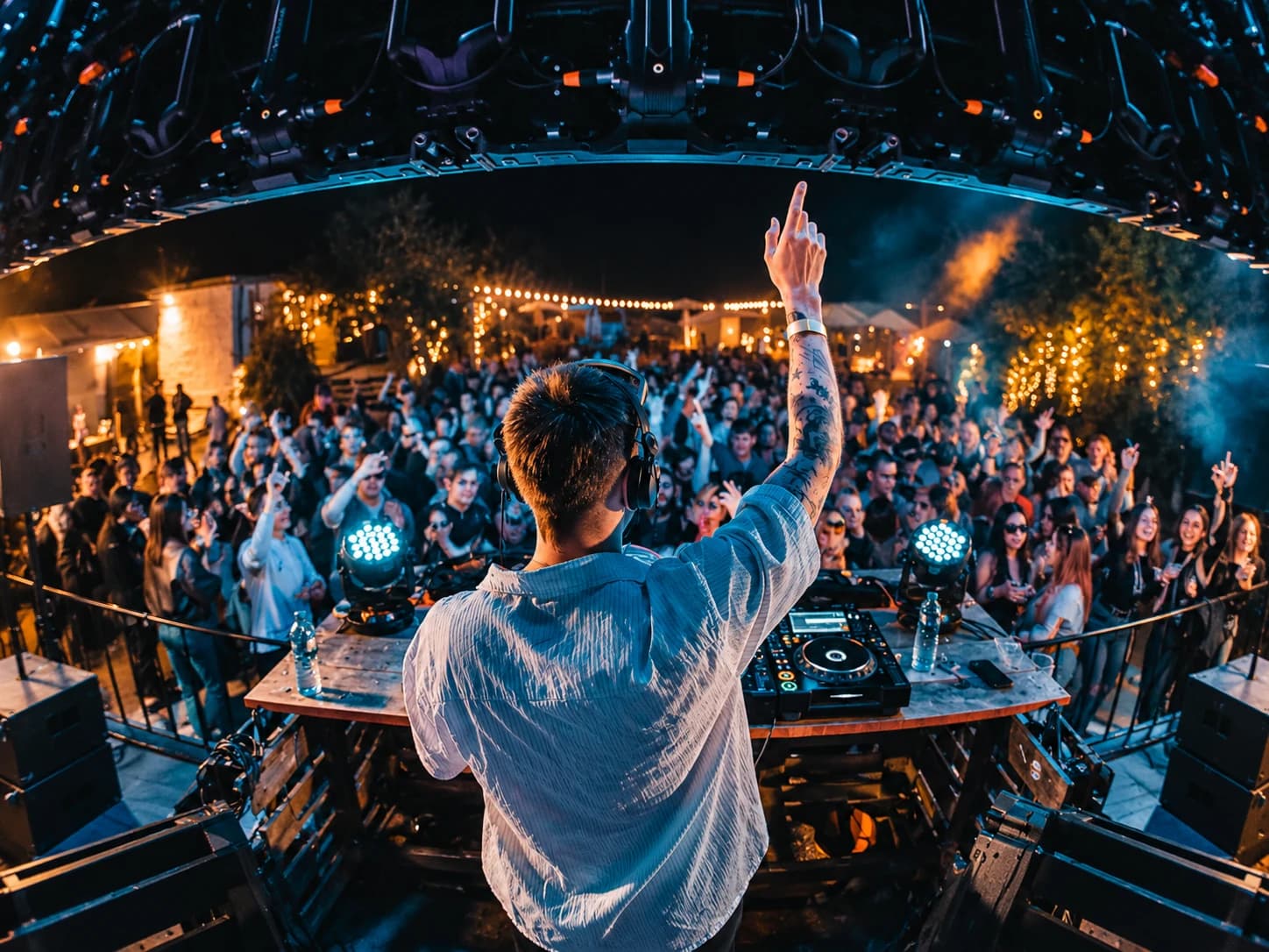DJ pe scenă în fața publicului, la un eveniment în aer liber, noaptea