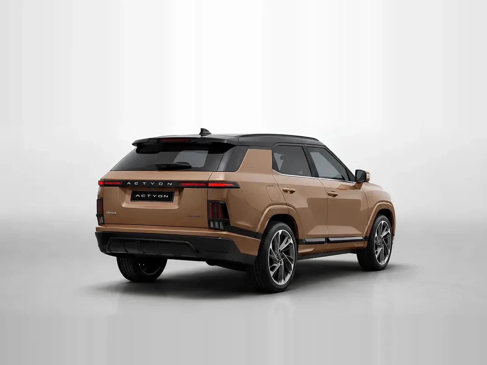 SUV KGM Actyon bronz, văzut din spate, pe fundal de studio